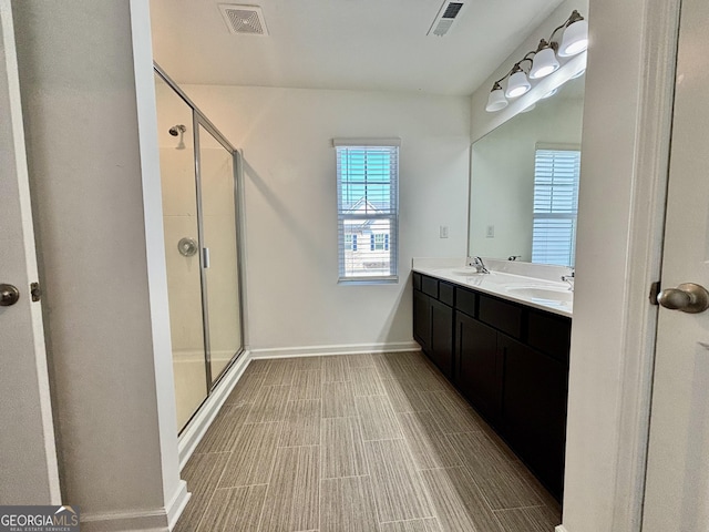 bathroom featuring vanity and a shower with shower door