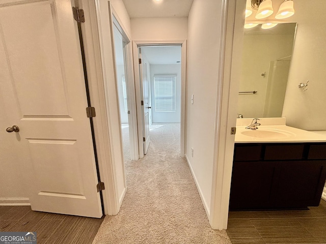 hall featuring sink and light colored carpet