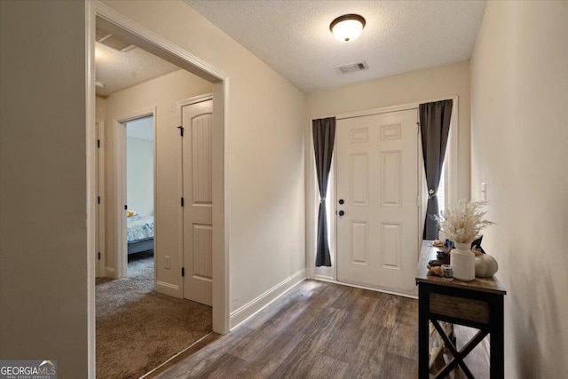 foyer with dark hardwood / wood-style flooring and a textured ceiling