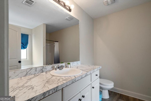 bathroom with vanity, toilet, a textured ceiling, walk in shower, and wood-type flooring