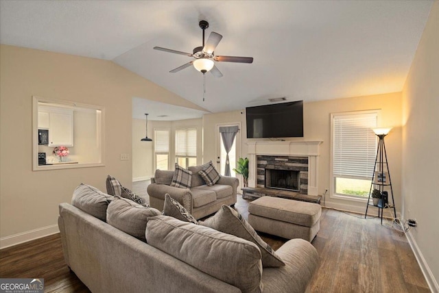 living room with a fireplace, dark hardwood / wood-style floors, vaulted ceiling, and ceiling fan