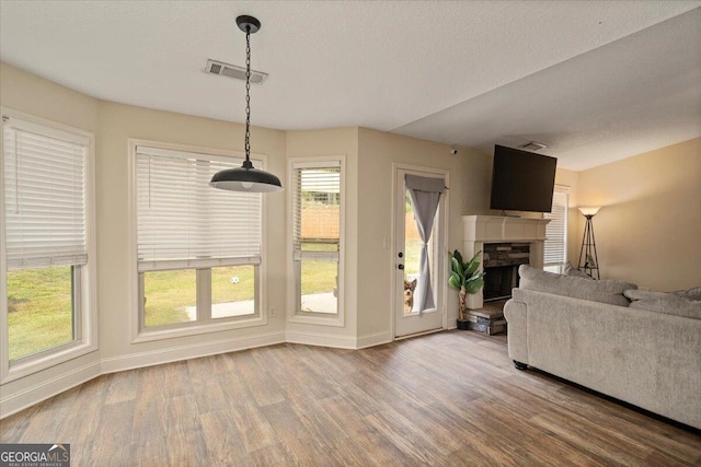 unfurnished living room with a fireplace, hardwood / wood-style floors, and a textured ceiling