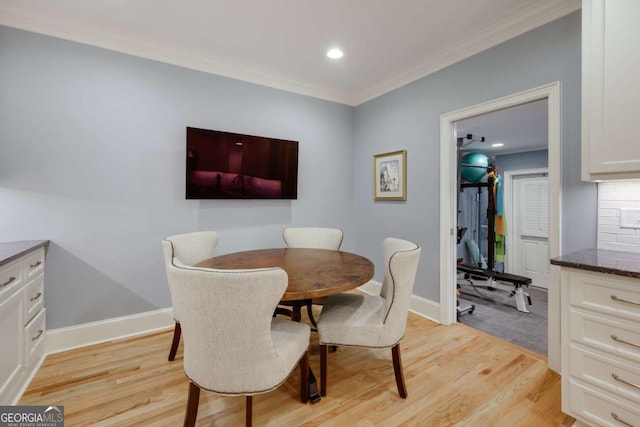 dining area featuring crown molding and light hardwood / wood-style floors