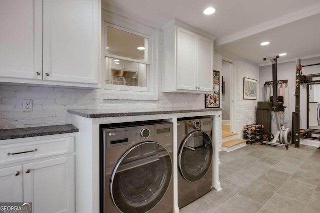 clothes washing area featuring cabinets, independent washer and dryer, and crown molding