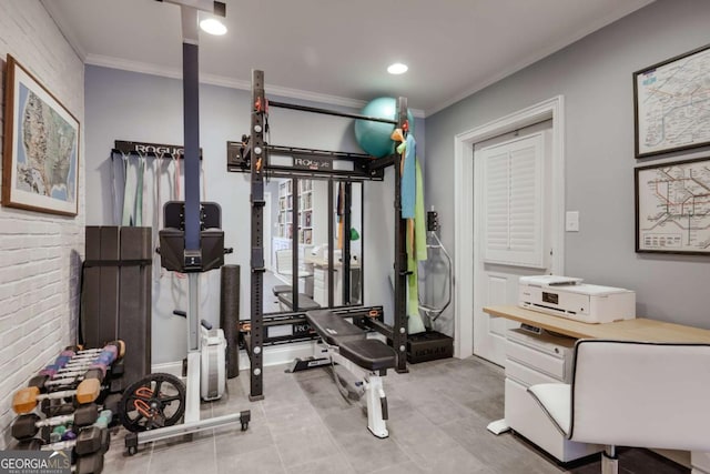 workout room with ornamental molding and brick wall