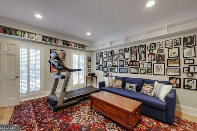 workout room with crown molding and hardwood / wood-style flooring