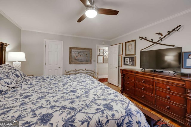 bedroom with hardwood / wood-style floors, ceiling fan, and crown molding