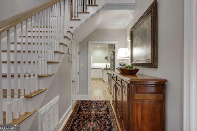 interior space with crown molding and light wood-type flooring