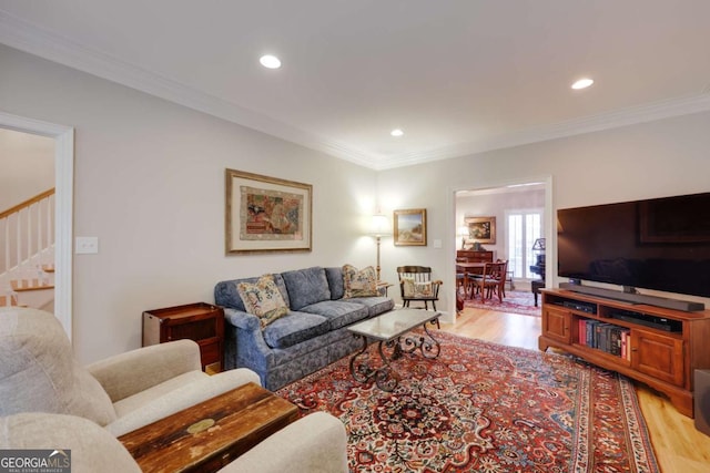 living room featuring light wood-type flooring and crown molding