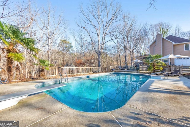 view of pool featuring a diving board and a patio