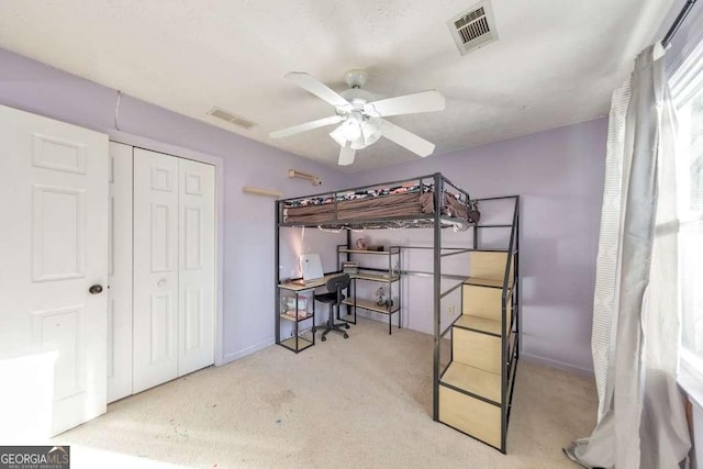 carpeted bedroom featuring ceiling fan and a closet