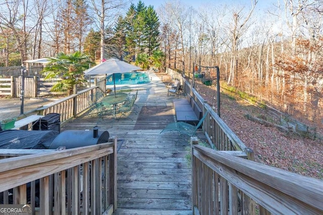 wooden terrace featuring a swimming pool