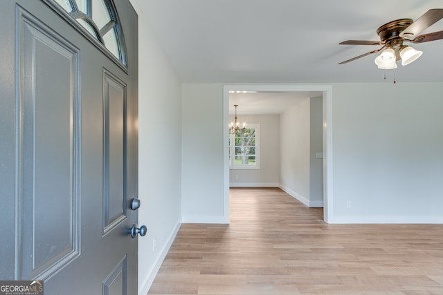 foyer entrance featuring ceiling fan with notable chandelier and light wood-type flooring