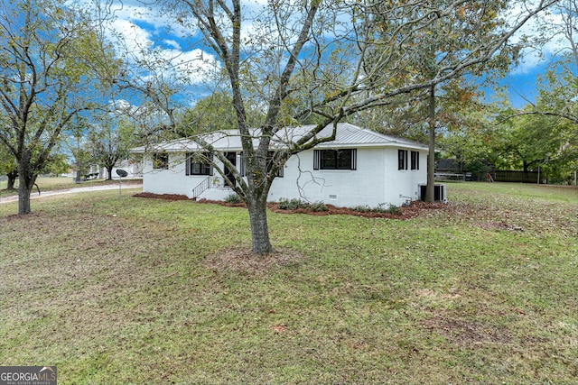 view of front of house with cooling unit and a front lawn