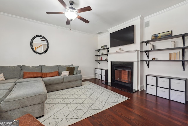 living room with ceiling fan, ornamental molding, and dark wood-type flooring