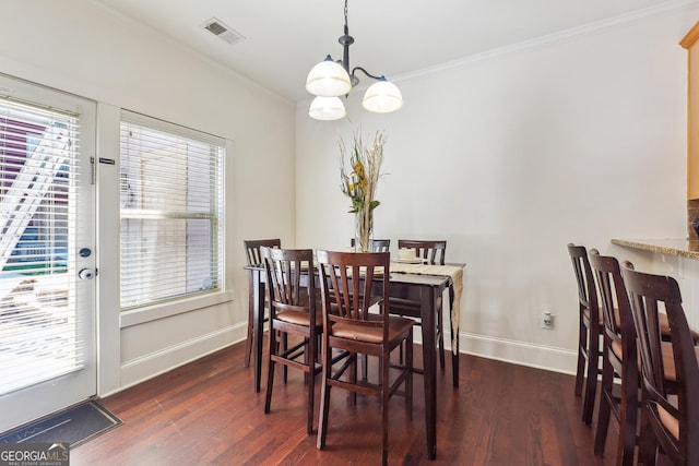 dining area with a healthy amount of sunlight, crown molding, dark wood-type flooring, and an inviting chandelier