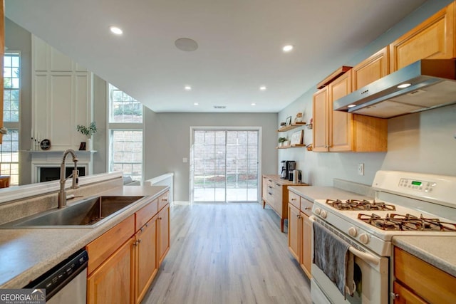 kitchen with sink, white gas range oven, plenty of natural light, light hardwood / wood-style floors, and extractor fan