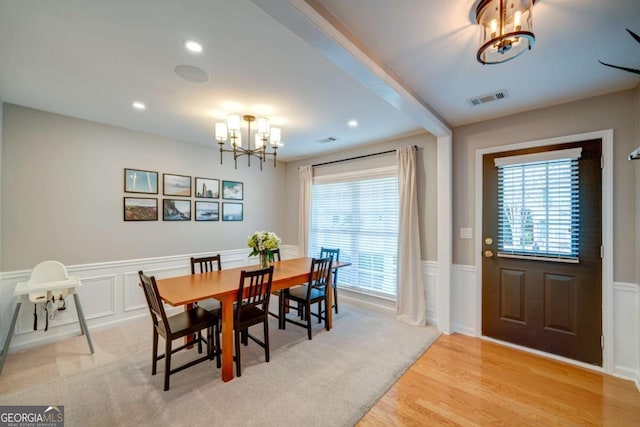 carpeted dining room featuring a chandelier