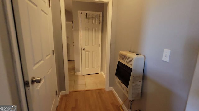 corridor featuring heating unit and light hardwood / wood-style flooring