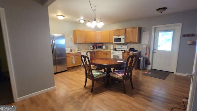 dining room with a chandelier and light wood-type flooring