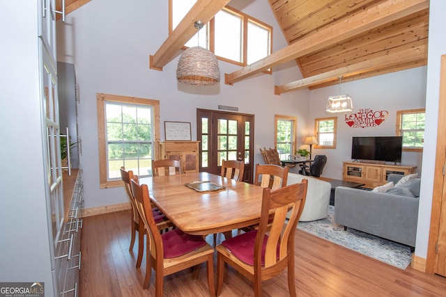 dining space with beamed ceiling, high vaulted ceiling, an inviting chandelier, and hardwood / wood-style flooring