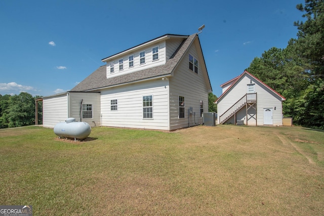 rear view of property featuring a yard and central AC