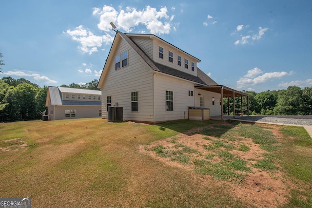 back of property with central air condition unit and a yard