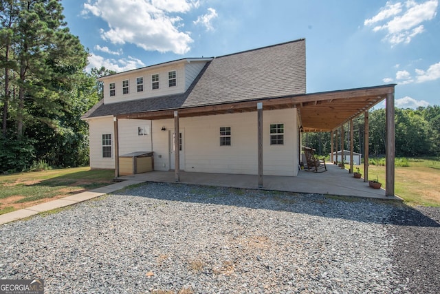 rear view of house featuring a lawn and a patio area