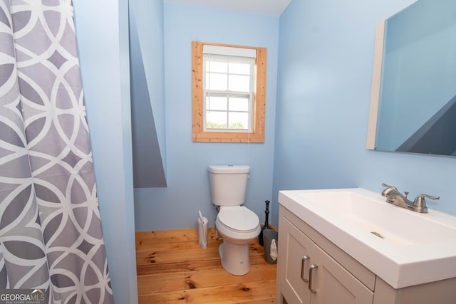 bathroom with wood-type flooring, vanity, and toilet