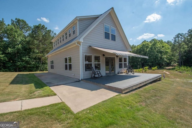 back of property featuring a lawn, a wooden deck, and french doors