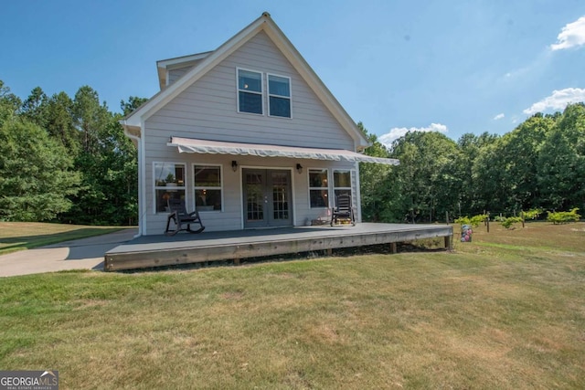 rear view of property featuring a lawn and french doors