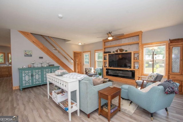 living room featuring ceiling fan, a wealth of natural light, and light hardwood / wood-style flooring