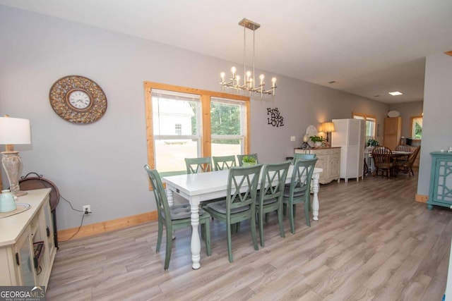 dining room featuring light hardwood / wood-style floors and a notable chandelier