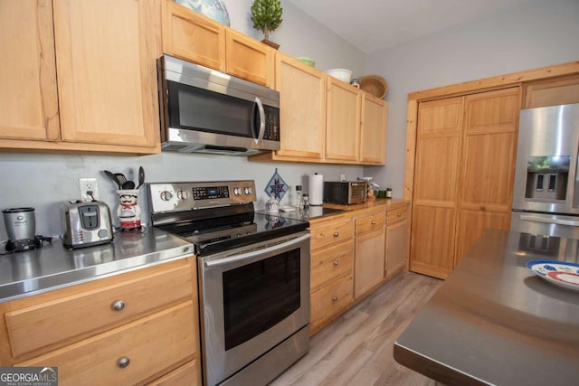 kitchen with light brown cabinets, stainless steel appliances, stainless steel counters, and light hardwood / wood-style floors