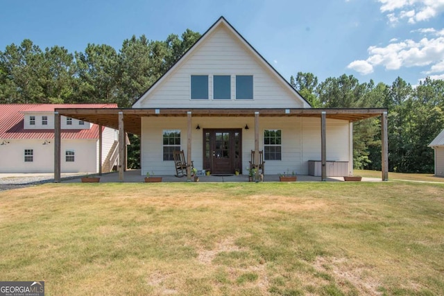 rear view of property featuring a lawn and a porch