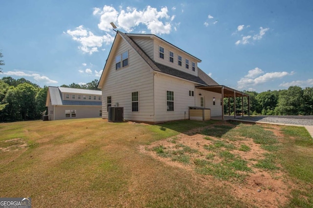 back of property featuring a yard and central AC