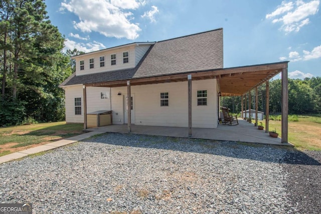 rear view of property featuring a patio and a lawn