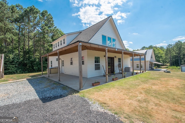 rear view of house featuring a patio area and a yard