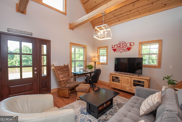 living room featuring beam ceiling, high vaulted ceiling, hardwood / wood-style flooring, and an inviting chandelier