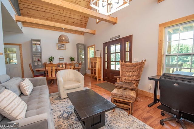 living room featuring light wood-type flooring, high vaulted ceiling, wooden ceiling, a notable chandelier, and beamed ceiling