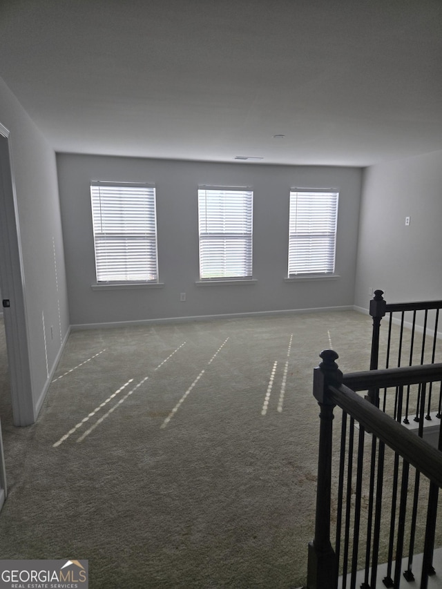 interior space with carpet floors and multiple windows