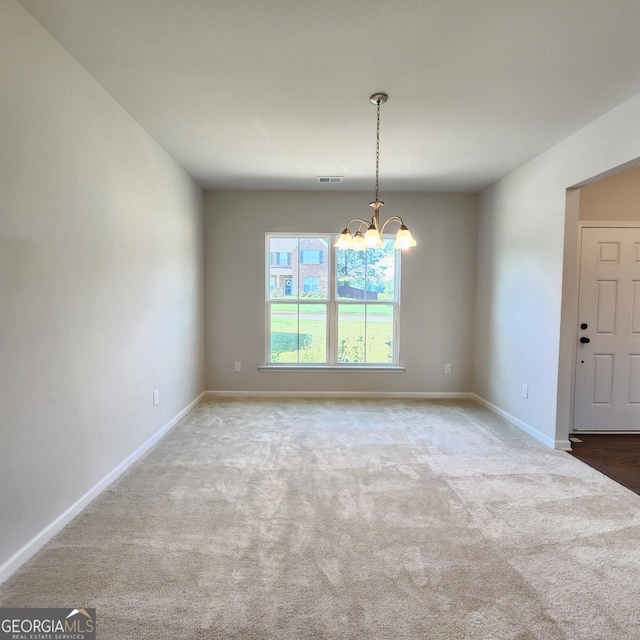 unfurnished room featuring carpet floors and a chandelier