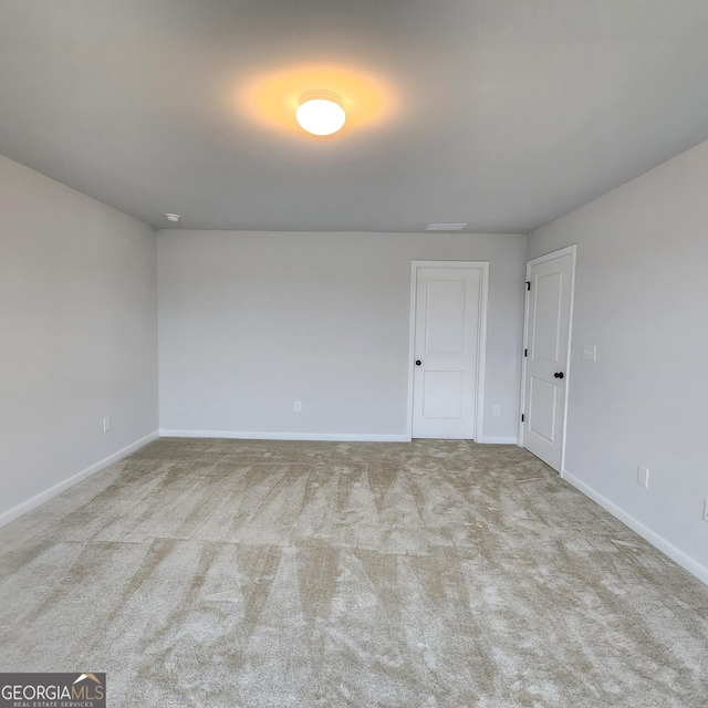 unfurnished room featuring light colored carpet