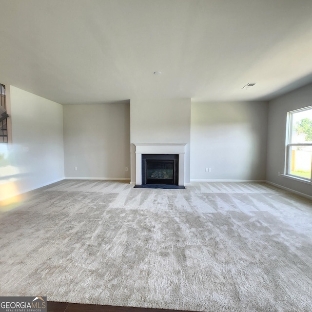 unfurnished living room with light colored carpet