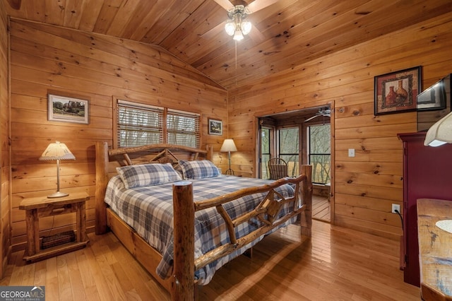 bedroom featuring ceiling fan, light hardwood / wood-style flooring, vaulted ceiling, wooden walls, and wood ceiling