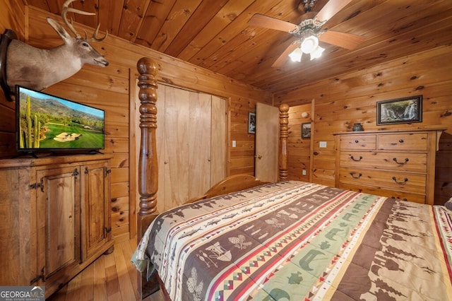 bedroom featuring hardwood / wood-style floors, ceiling fan, wooden walls, and wooden ceiling