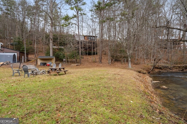 view of yard featuring a water view and an outdoor structure