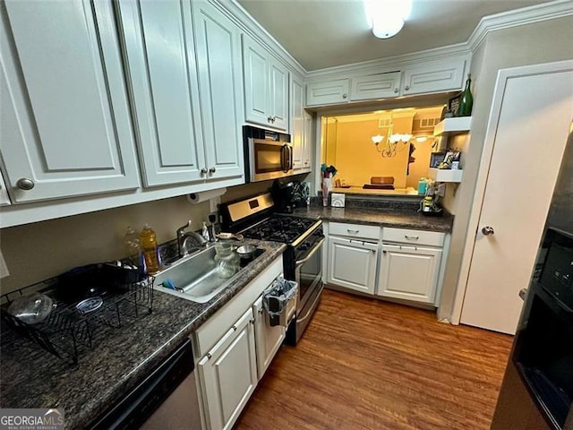 kitchen with white cabinetry, sink, stainless steel appliances, dark hardwood / wood-style floors, and a chandelier