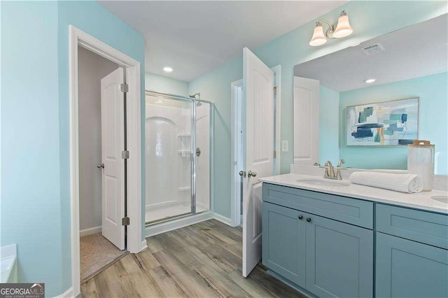 bathroom featuring hardwood / wood-style floors, vanity, and walk in shower