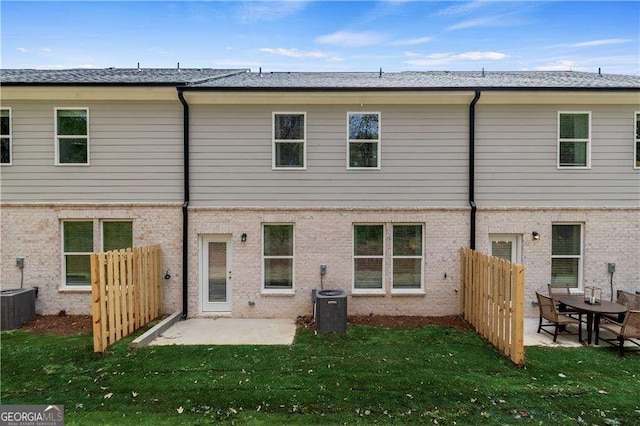 rear view of house with a yard, a patio, and central air condition unit